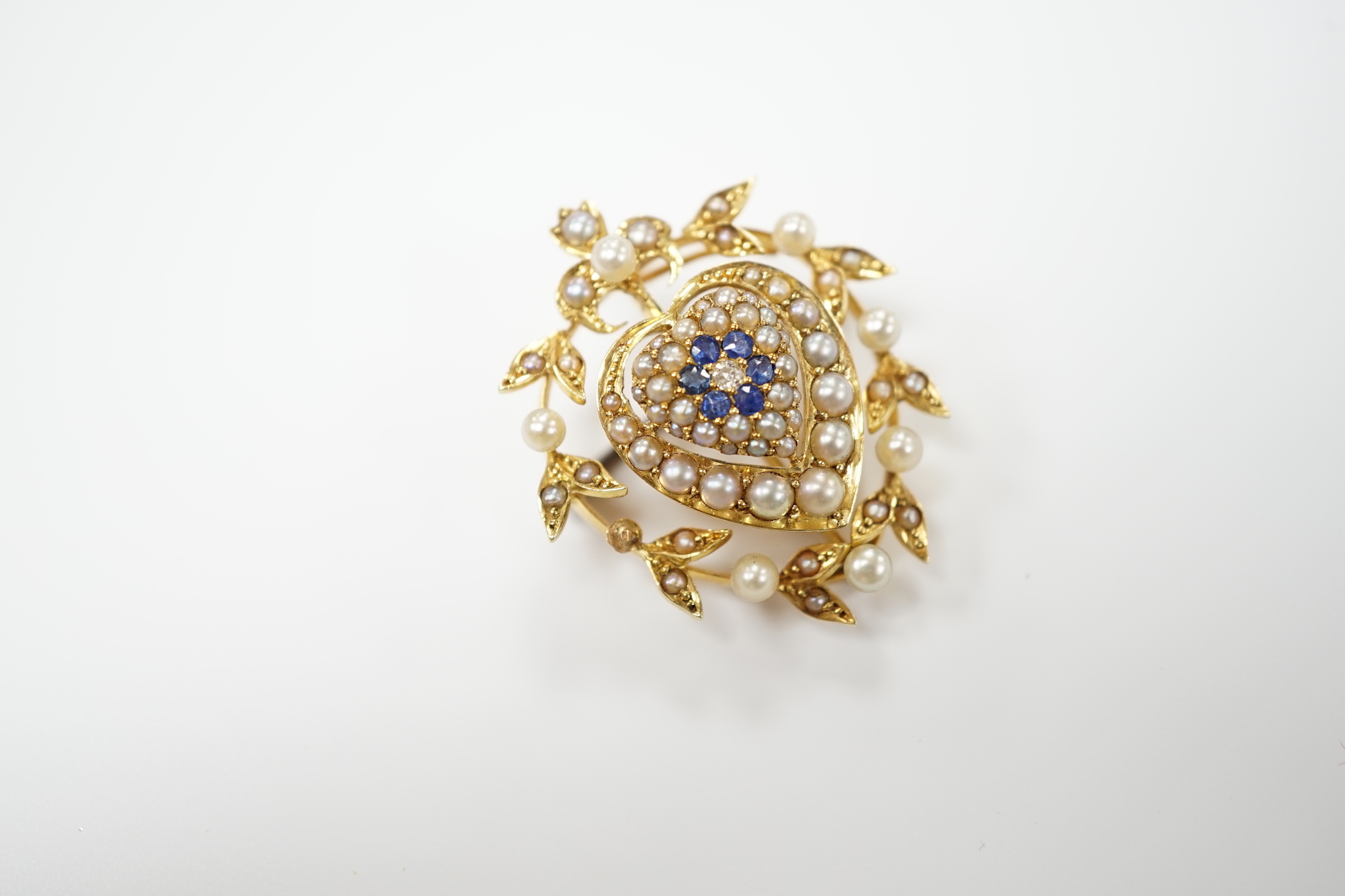 A yellow metal, sapphire, diamond and seed pearl set pendant brooch, with central heart motif, 30mm, gross weight 6.8 grams.